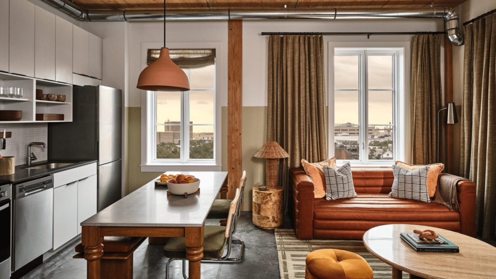 Open-plan Savannah residence with a kitchen, dining table, leather sofa, and tall windows.